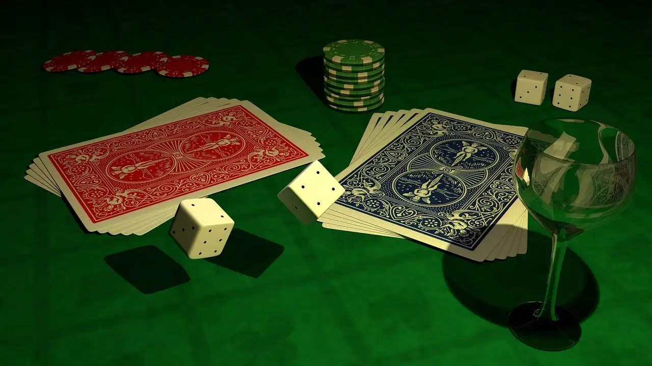 A deck of cards and dice on a green tableDescription automatically generated