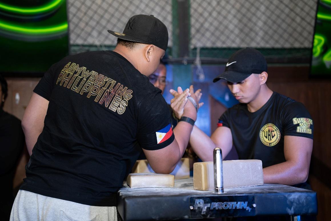 A person in black shirt and cap touching another person's hand

Description automatically generated