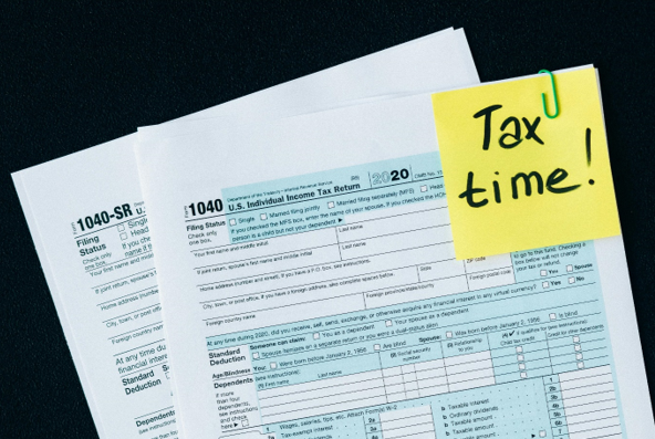 Picture of tax forms with post it note saying Tax time!