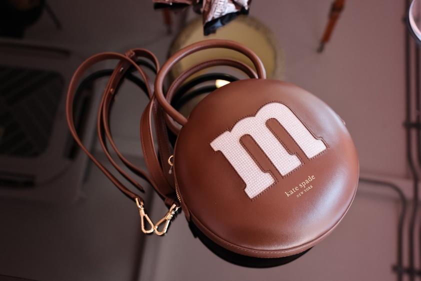 A brown purse with a m on it

Description automatically generated