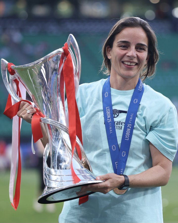 Treinadora do Arsenal segurando a taça da Champions League feminina
