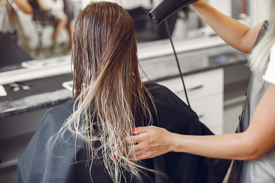 Stylist drying a client’s hair in a salon