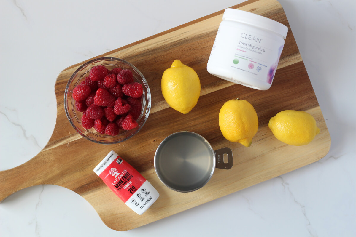 Raspberry lemonade electrolyte popsicles ingredients on wooden board