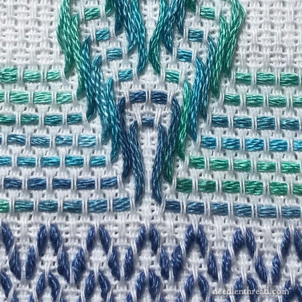 A close up of a cross stitch

Description automatically generated