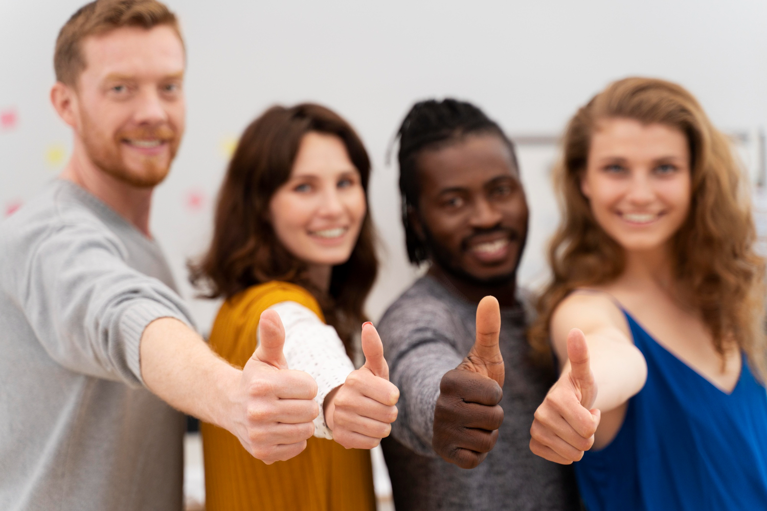 A group of happy and engaged employees gives a thumbs-up, showing the positive effects of a supportive company culture.