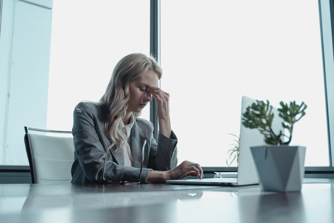 Stressed new manager facing onboarding challenges and common mistakes alone at her desk in an office.