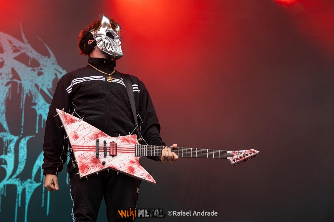 A person in a mask holding a guitar

AI-generated content may be incorrect.