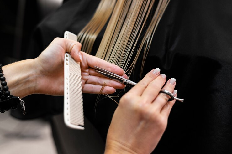 Woman getting her hair trimmed by a stylist