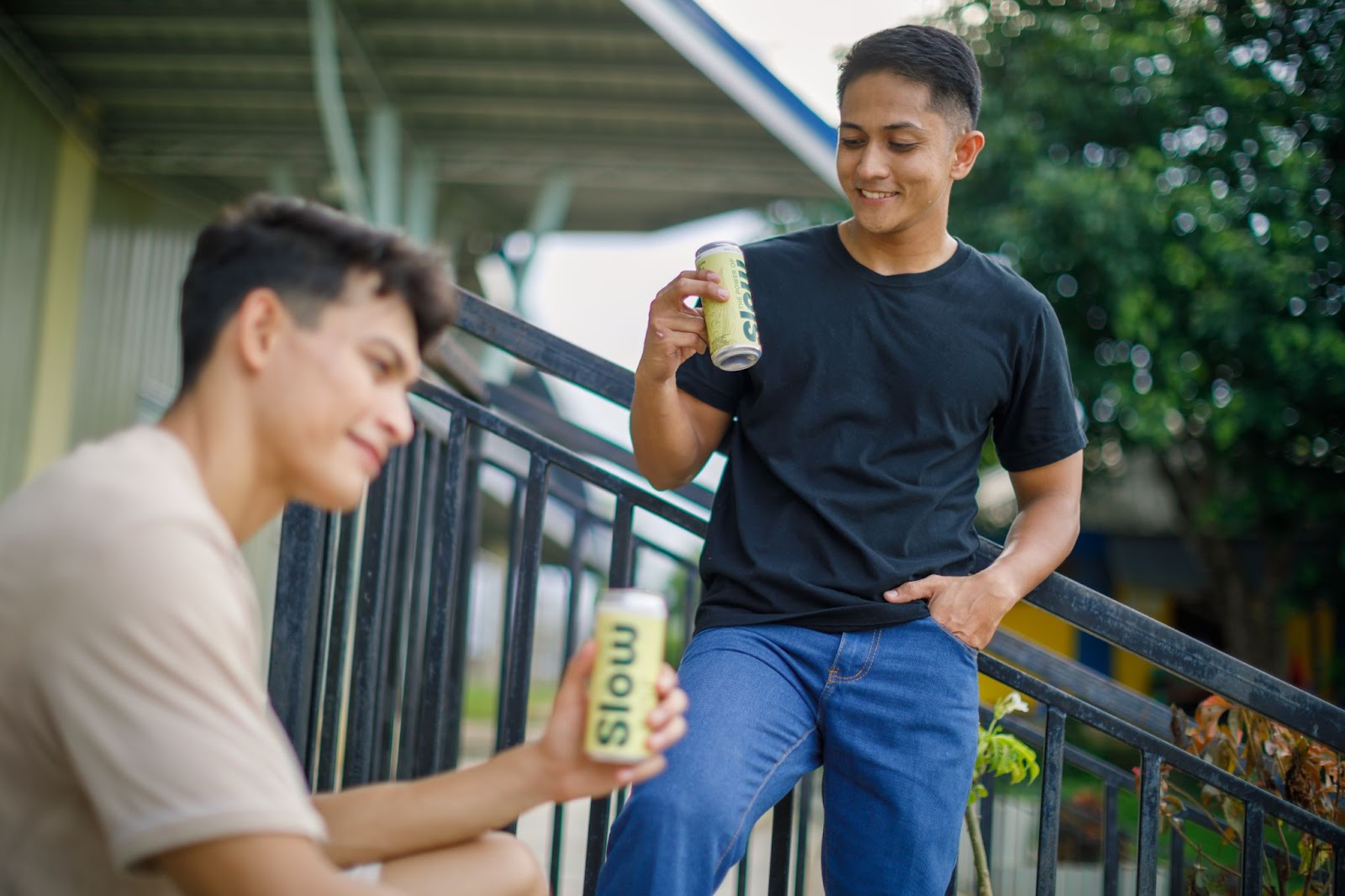 Young men holding SLOW beverage