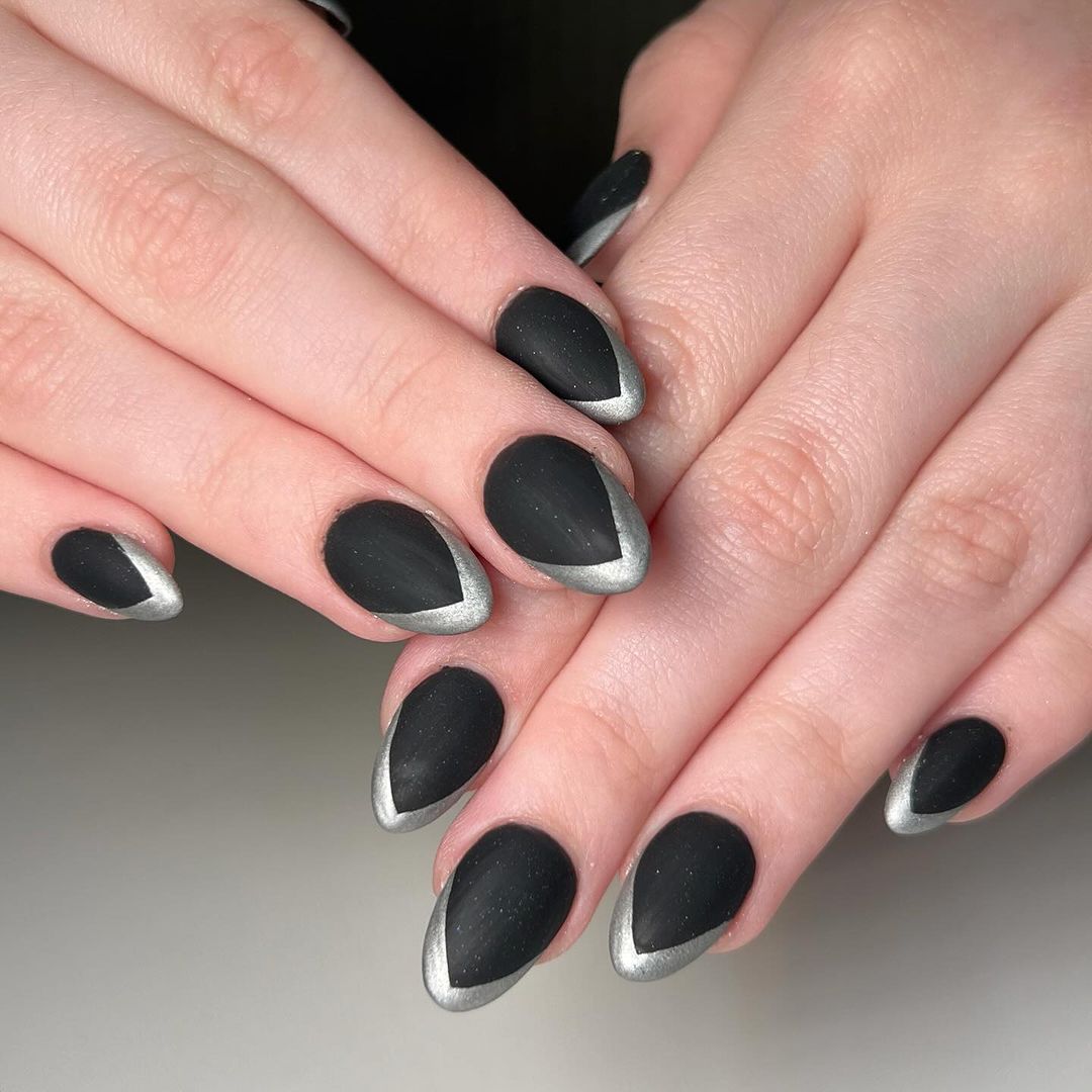 Close-up of a person's hands with black nails having Silver Chrome Stripes