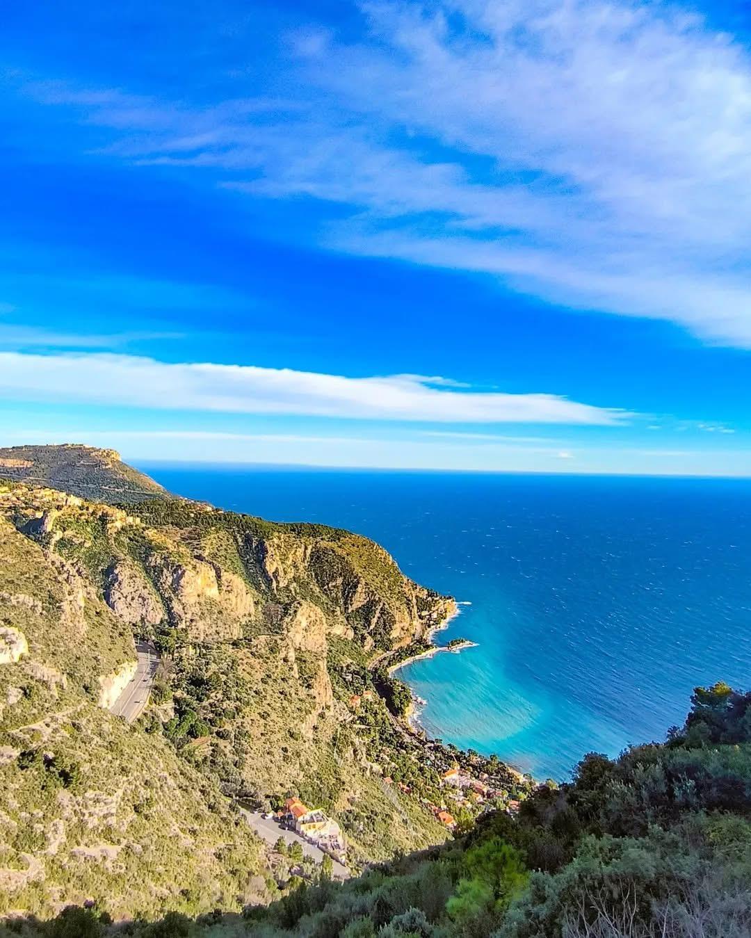 A landscape of a mountain with a body of water and a road

Description automatically generated