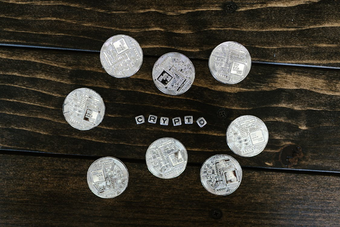 8 Solana cryptocurrency coins surrounding the word 'Crypto' on a wooden table background, showcasing Solana market influence