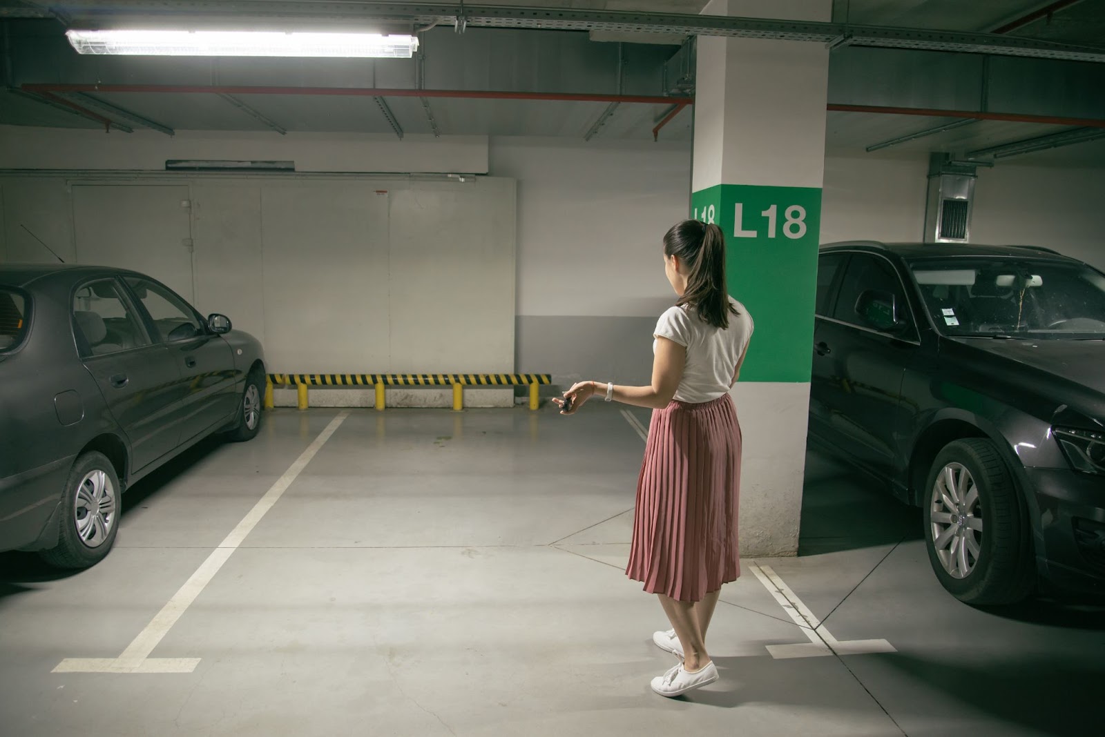Woman looking for her missing car in an underground parking garage
