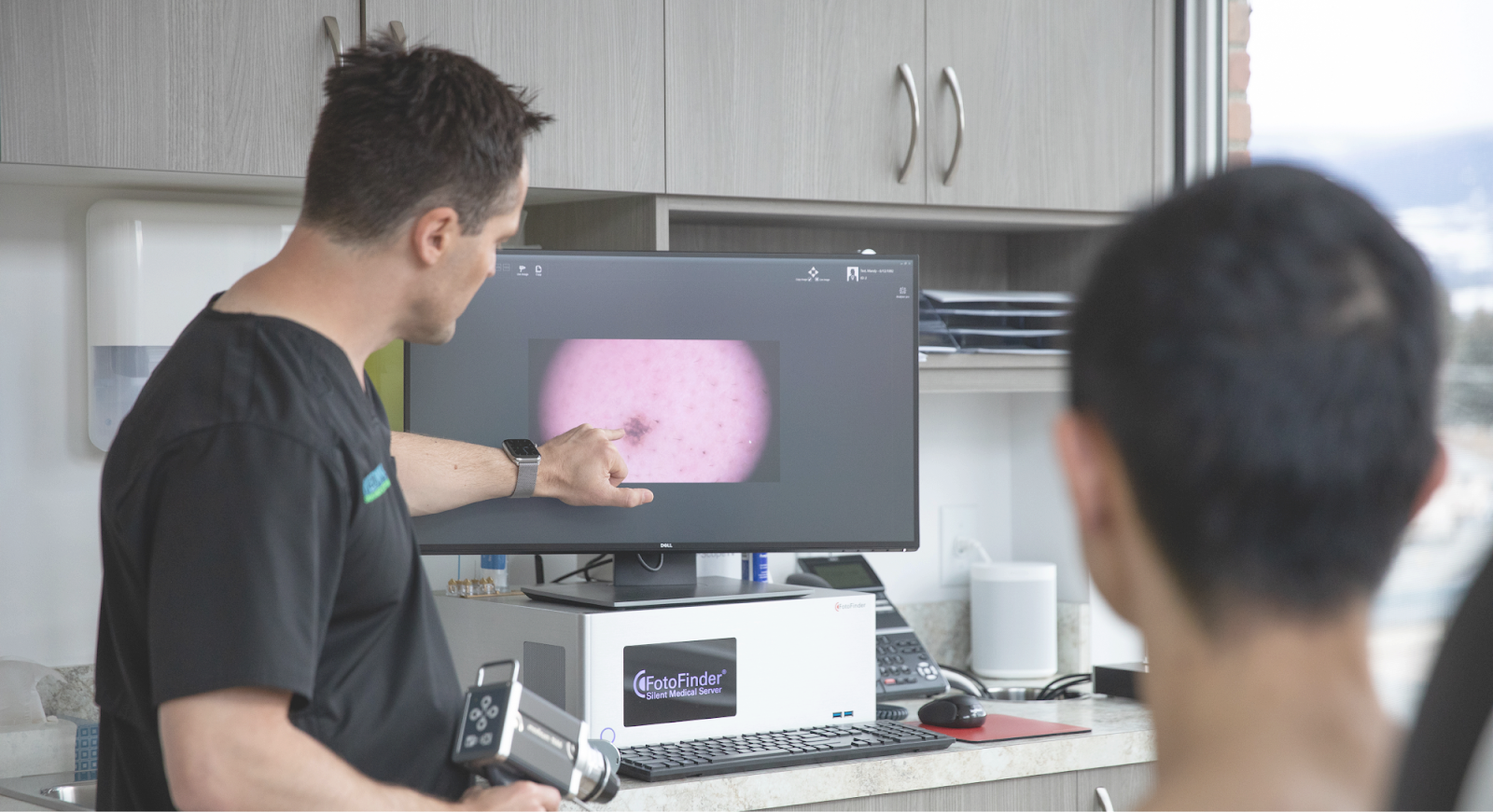 Dr Ben Wiese shows a patient a blemish on a foto finder screen in his office. 