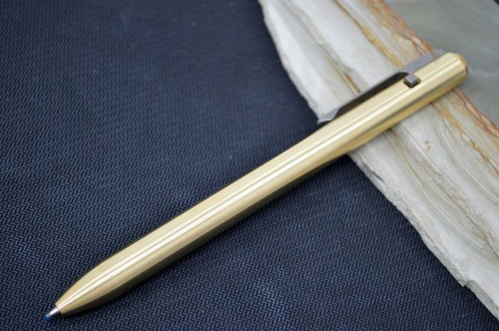 An image featuring the Tactile Turn Side Click Standard Pen in solid black and wood background. The pen features a bronze handle and a titanium clip.