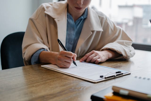 person writing on a document