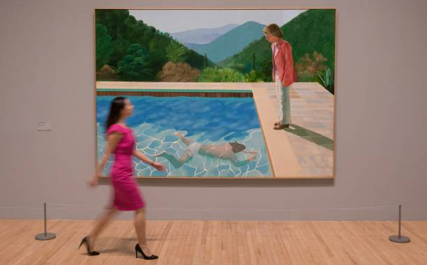  woman in a pink dress hoping to consign David Hockney art, walks past, Portrait of An Artist (Pool with Two Figures), by David Hockney, value unknown.