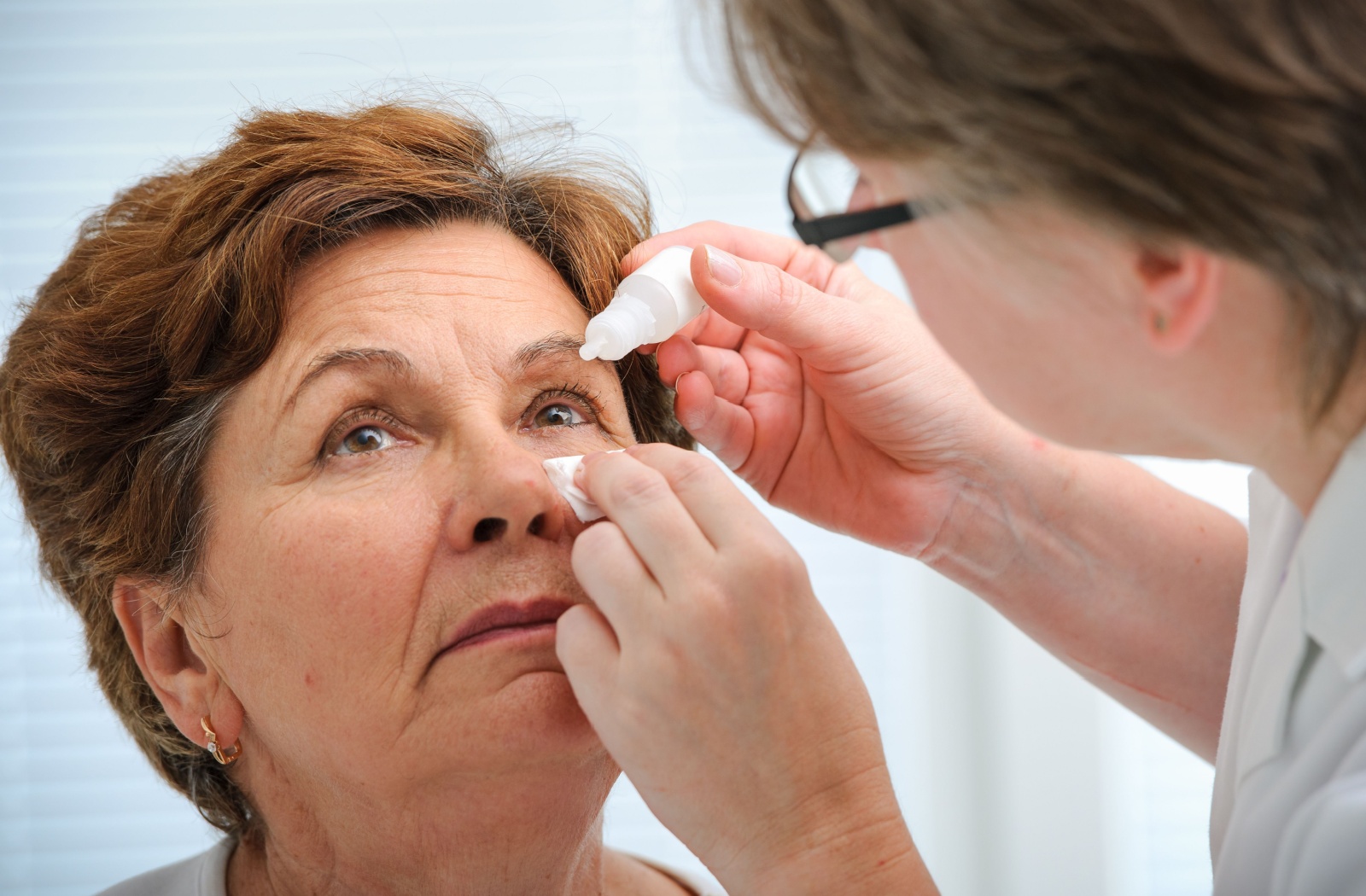 A healthcare professional applying eye drops to an older adult’s eye, highlighting treatment for dry eyes and vision discomfort.