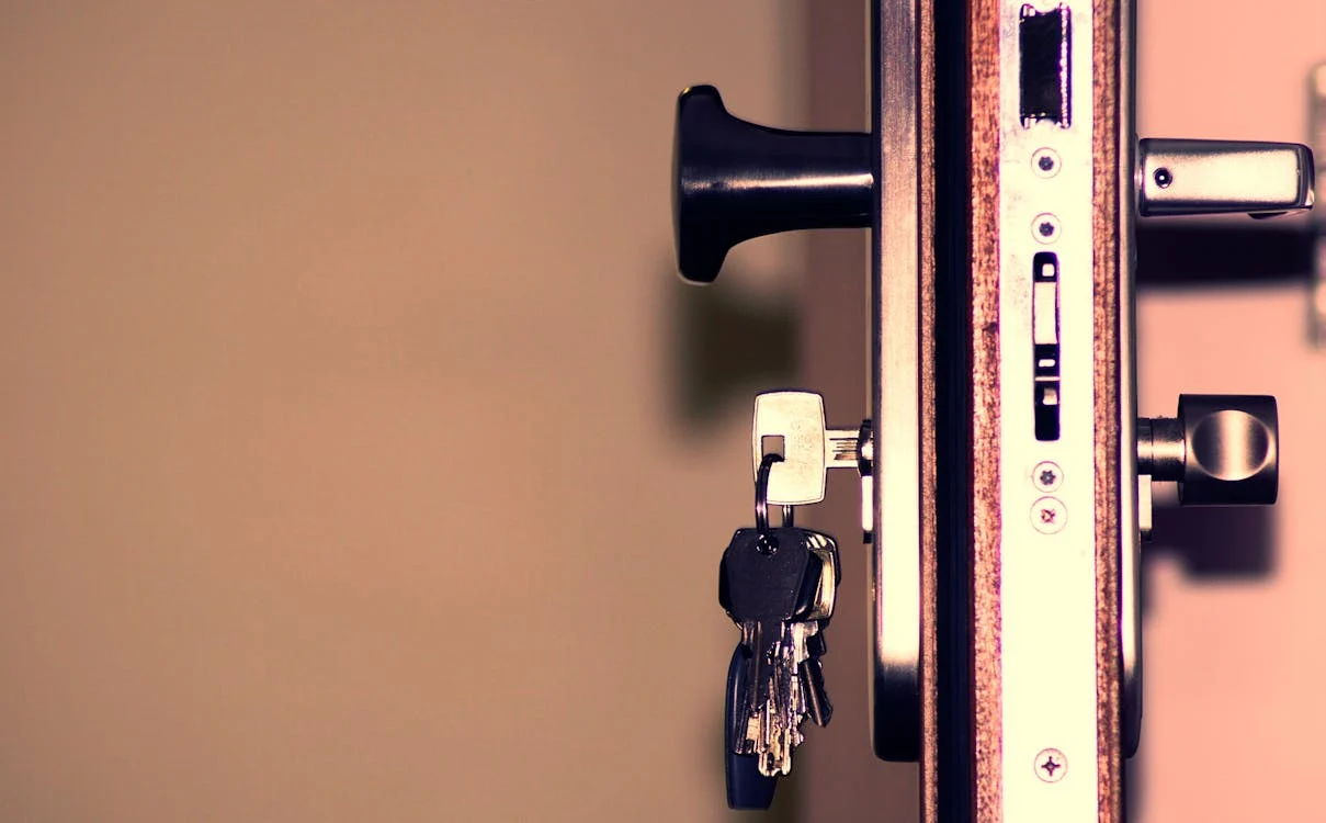 A close-up of a door lock with a set of keys inserted, showing various locking mechanisms and a modern handle design, emphasizing security and functionality