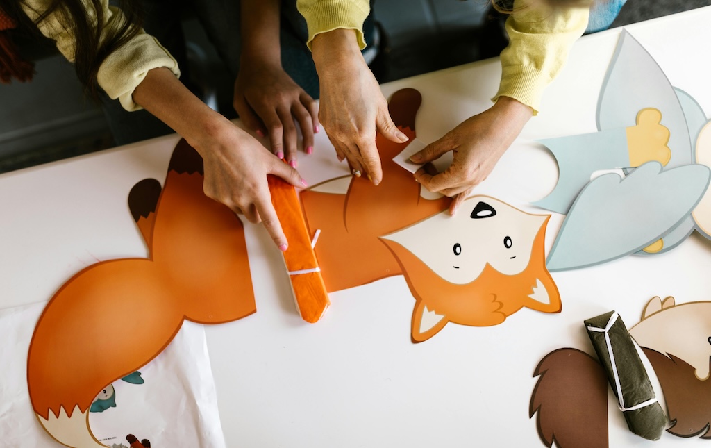 child and adult working on a fall craft project