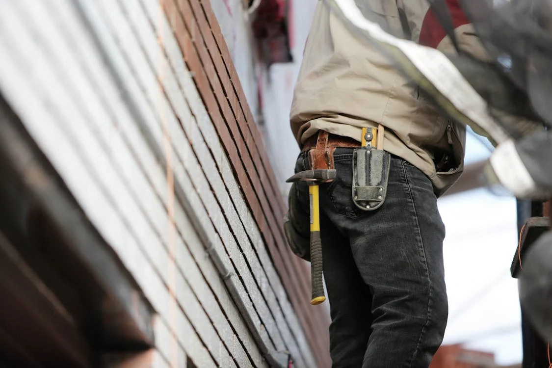 man wearing black denim pants with carrying hammer