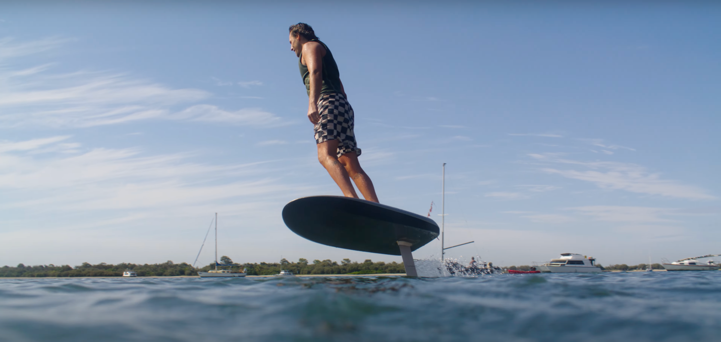 A person on a surfboard in the water

Description automatically generated