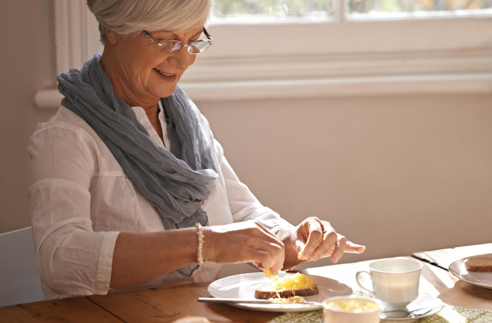 A happy senior enjoys a high-protein breakfast.
