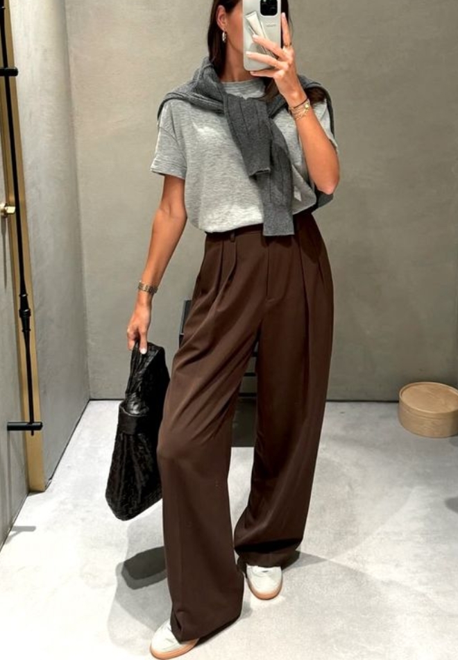 Wanita dengan trouser coklat dan kaus abu-abu.