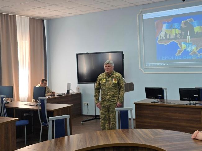 A person in military uniform standing in a room with a projection screenAI-generated content may be incorrect.