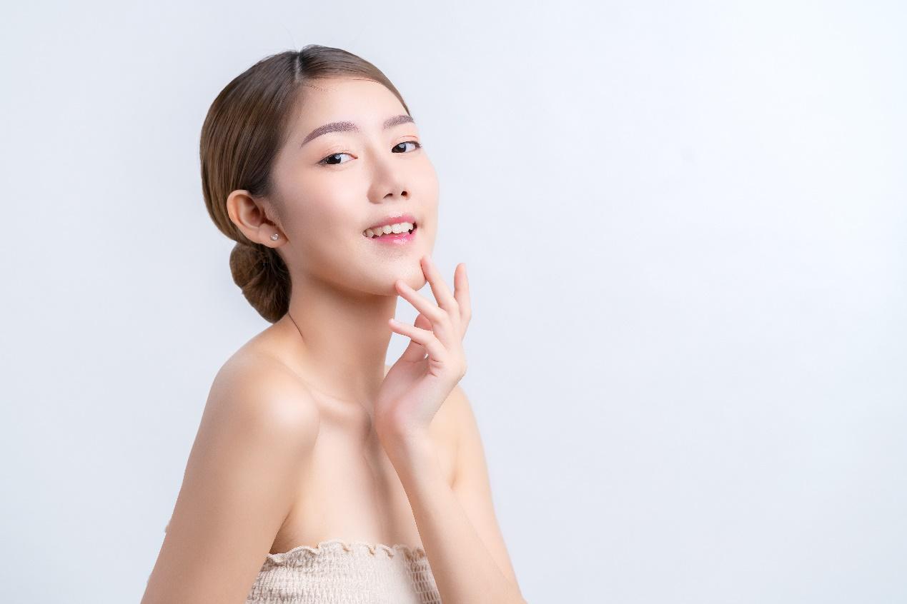A person with her hand on her face

Description automatically generated