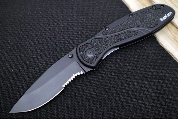 An image showing a folding knife with a partially serrated blade. The blade features a sleek black finish, which adds a layer of protection against corrosion and wear. The handle is ergonomically shaped with textured inlays for a secure grip.