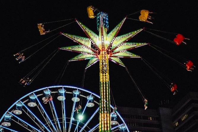 A ferris wheel and a ferris wheel at night

Description automatically generated