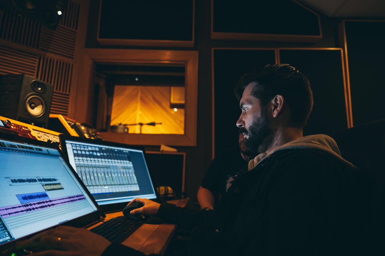 A music producer working in a dark recording studio