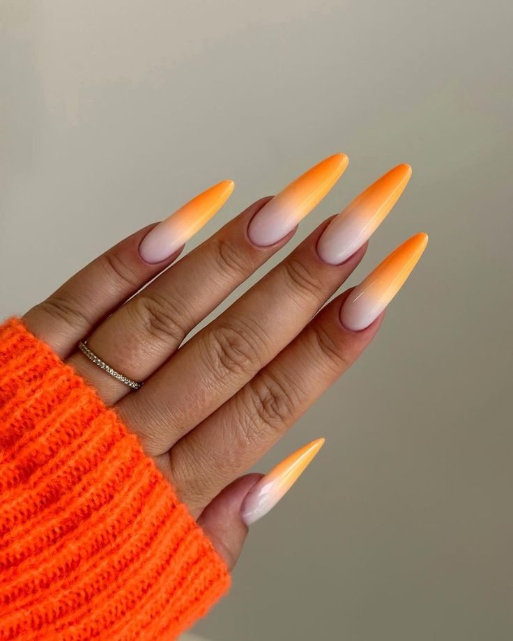 Close up of nails with glittery orange nails having Orange to White Fade