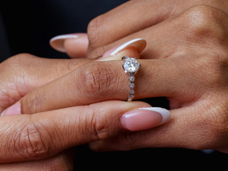 A person putting a diamond ring on their finger

AI-generated content may be incorrect.