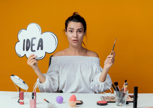 Female beauty blogger with makeup objects and holding a cloud cutout with the word "idea" on it