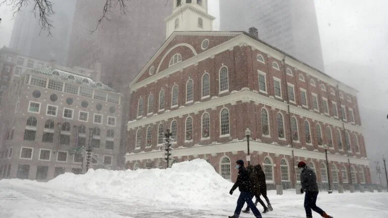 People walk in the snow outside Faneuil Hall during a snowstorm. 