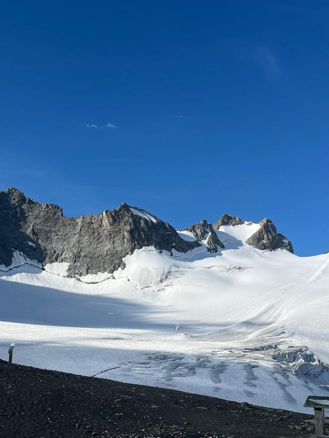 A snowy mountain with blue skyAI-generated content may be incorrect.