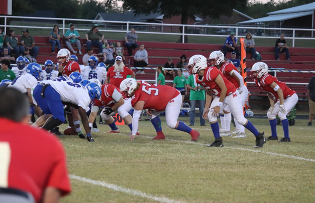 A group of football players on a field

Description automatically generated