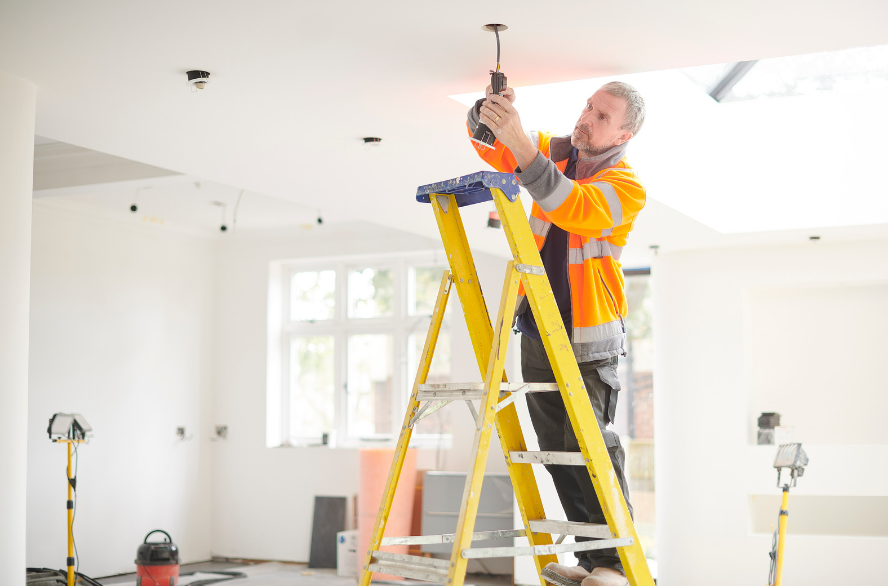 Electrician installing ceiling light