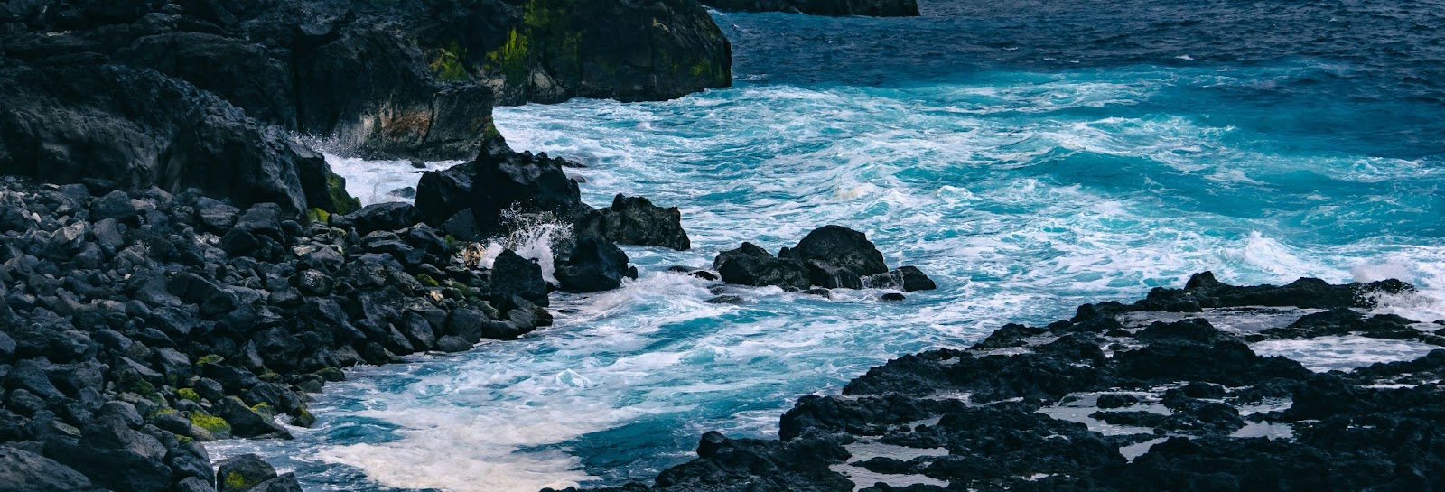 Ondas do mar batendo em rochas vulcânicas escuras na costa da Ilha de São Miguel, cenário marcante de onde fica a Ilha de São Miguel, em Portugal.