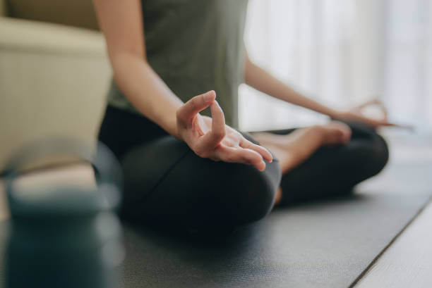 A woman sitting cross-legged in a peaceful meditation pose, representing a holistic approach to stress relief.