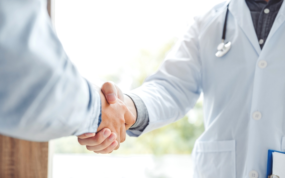 Two psychiatric mental health nurse practitioners shaking hands, symbolizing collaboration and teamwork in patient care.