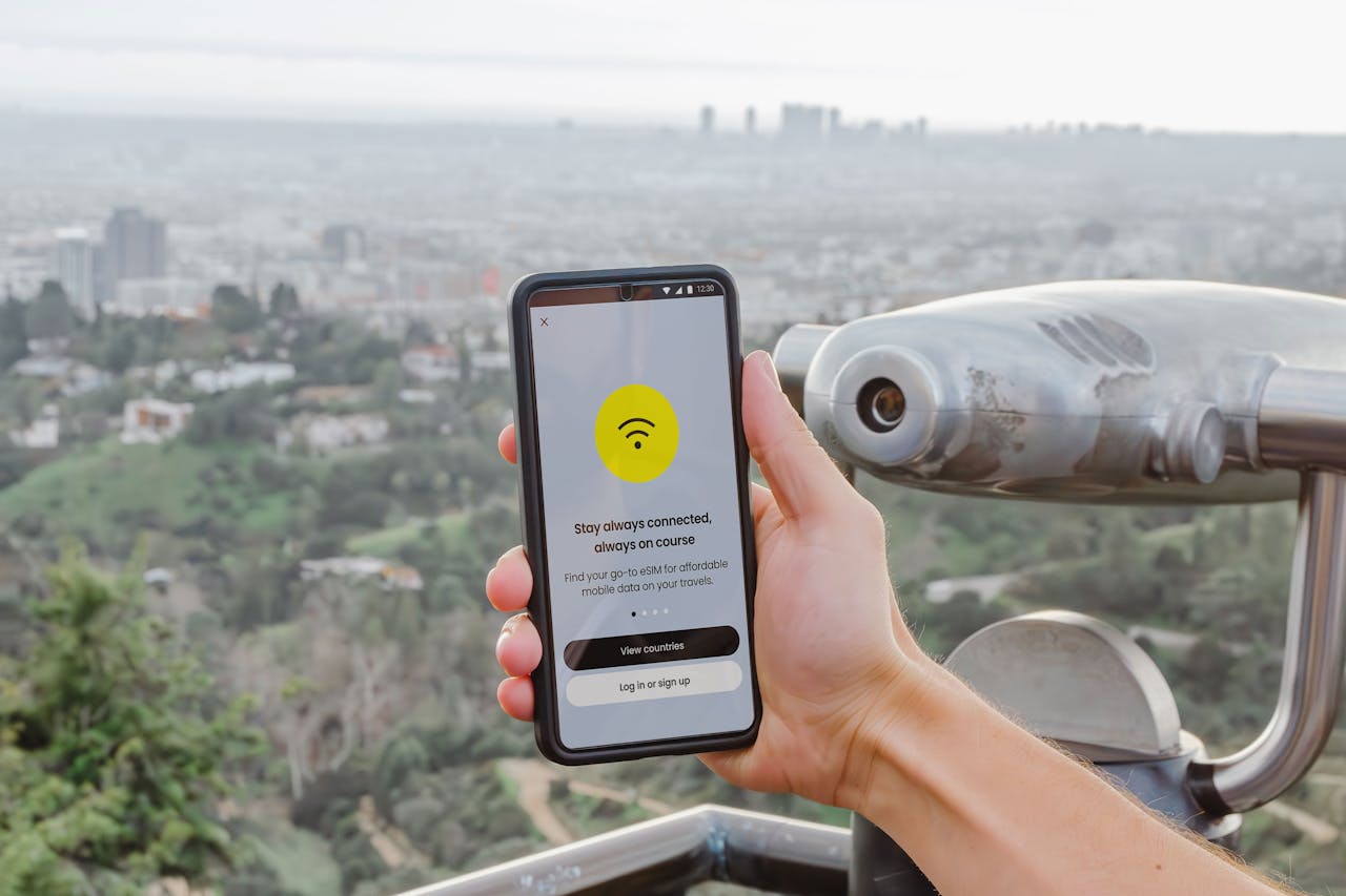 A person holding a smartphone displaying a mobile data connection app, with a cityscape in the background, emphasizing staying connected while traveling.