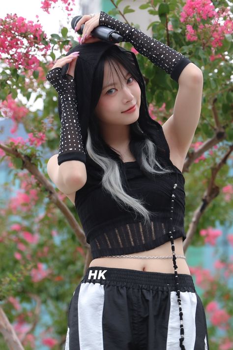 A photo of LE SSERAFIM's Eunchae wearing a black top and a black trouser with her hand on her head.