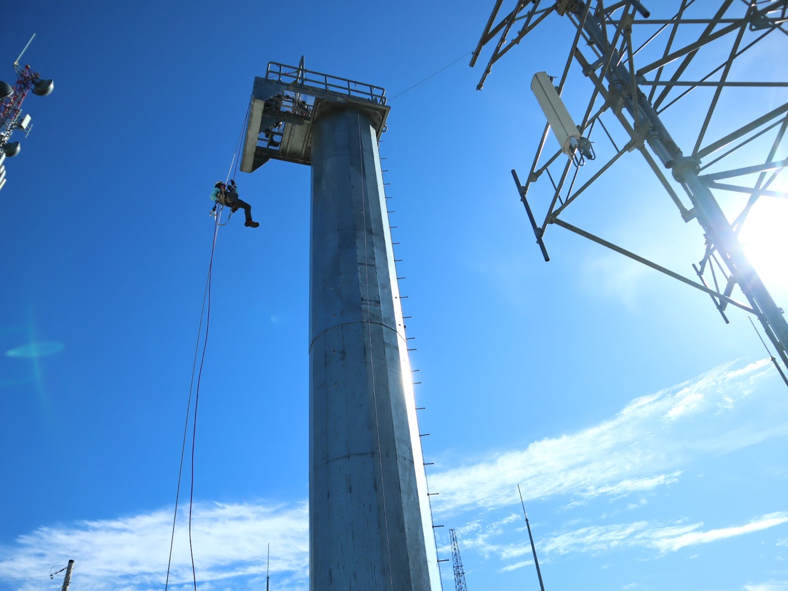 Tower Technician student at Pinnacle Career Institute performing a controlled descent during hands-on boot camp training. PCI’s hybrid trade school program prepares students for careers in telecommunications with real-world tower climbing, rigging, and rescue experience.