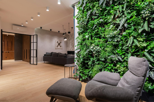 interior with armchair and pouf near living green wall