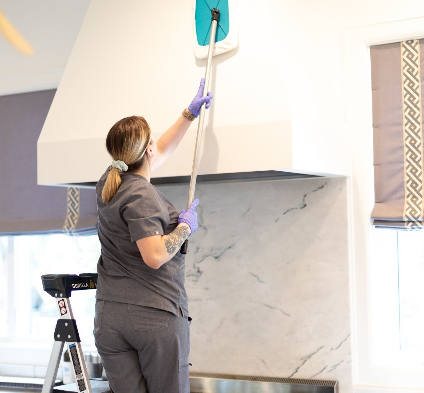 A Vella housekeeper wiping down the chimney with a Shy-mop. 