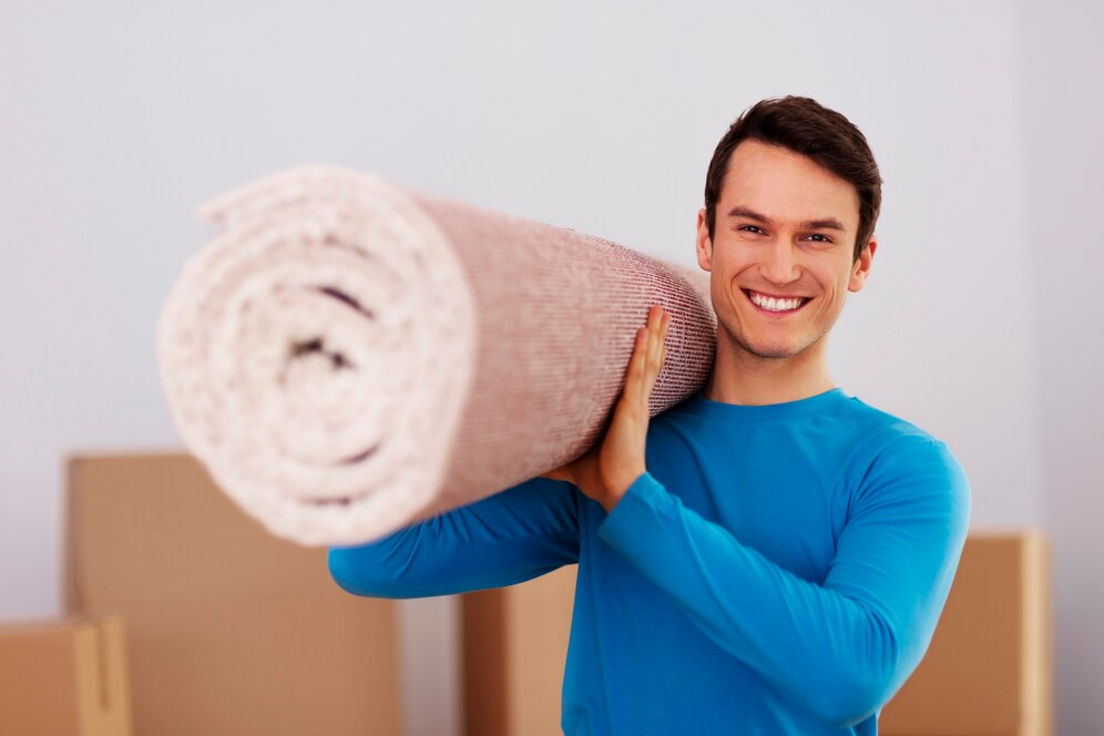A man holding carpet and smiling 