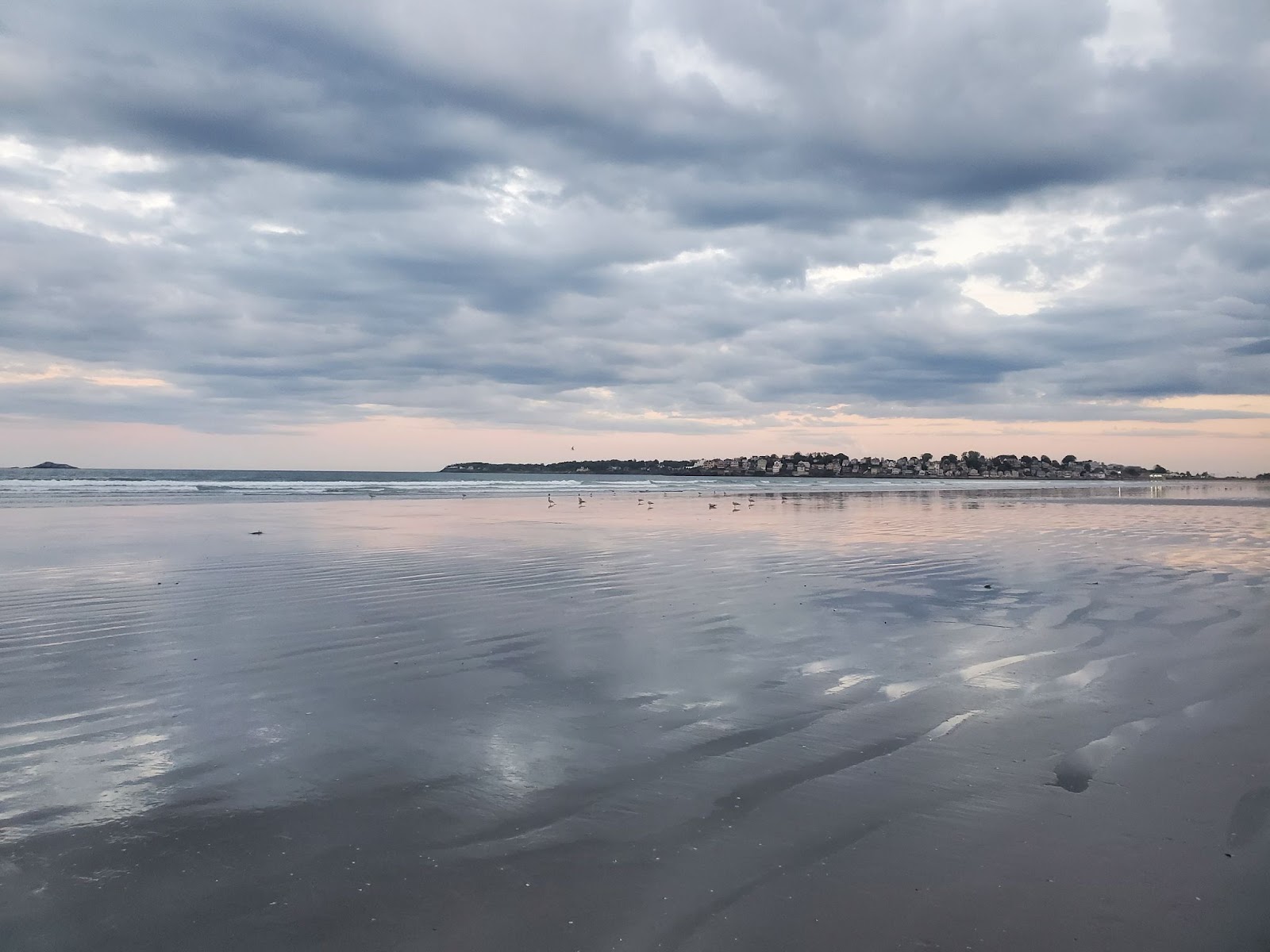 A pale pink and blue sunset reflects over Nahant Beach.